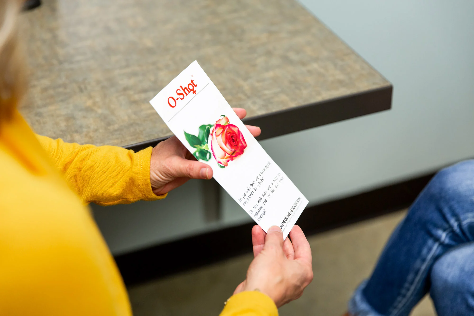 A woman holding a pamphlet about O-shot, containing information about exosomes in Sewickley.