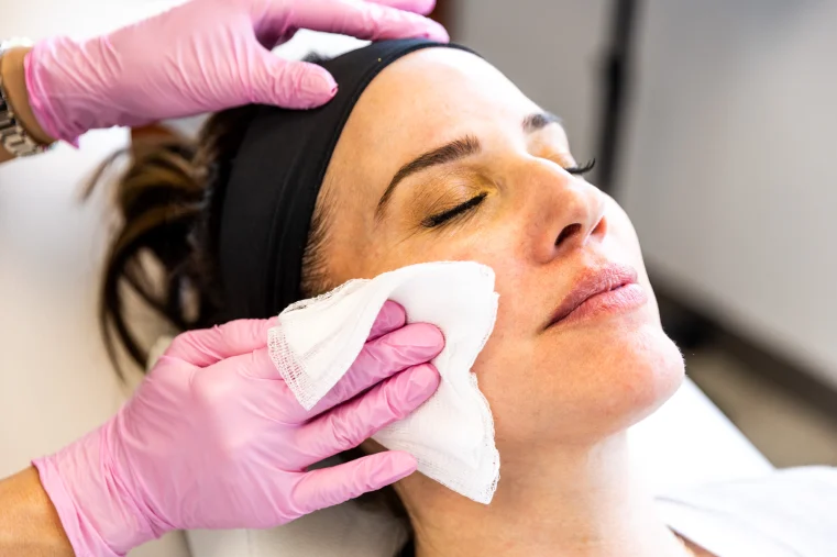 A woman's face is being wiped with a cloth after a skin care treatment near pittsburgh