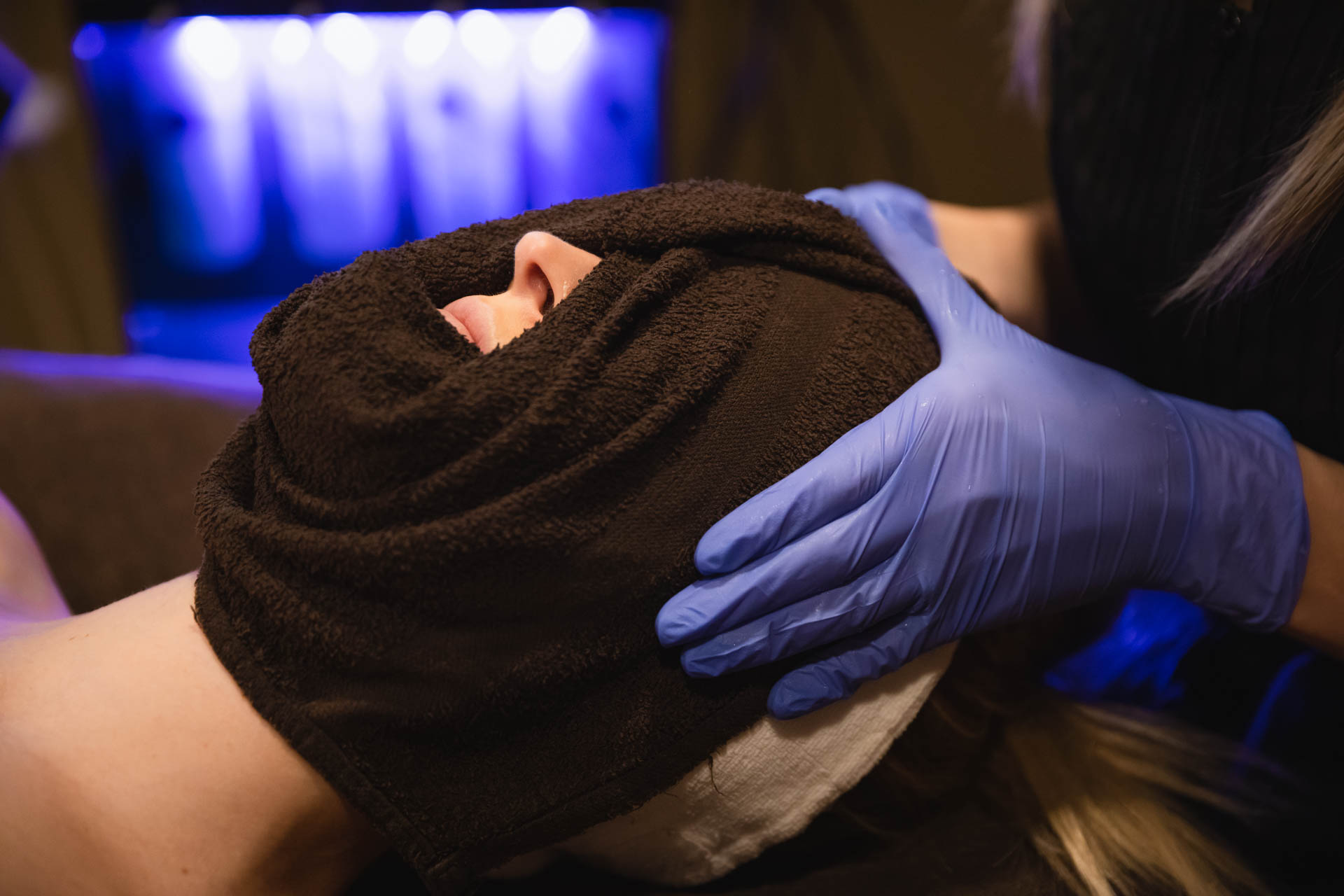 A womans face is wrapped up in a towel after her HydraFacial near Pittsburgh